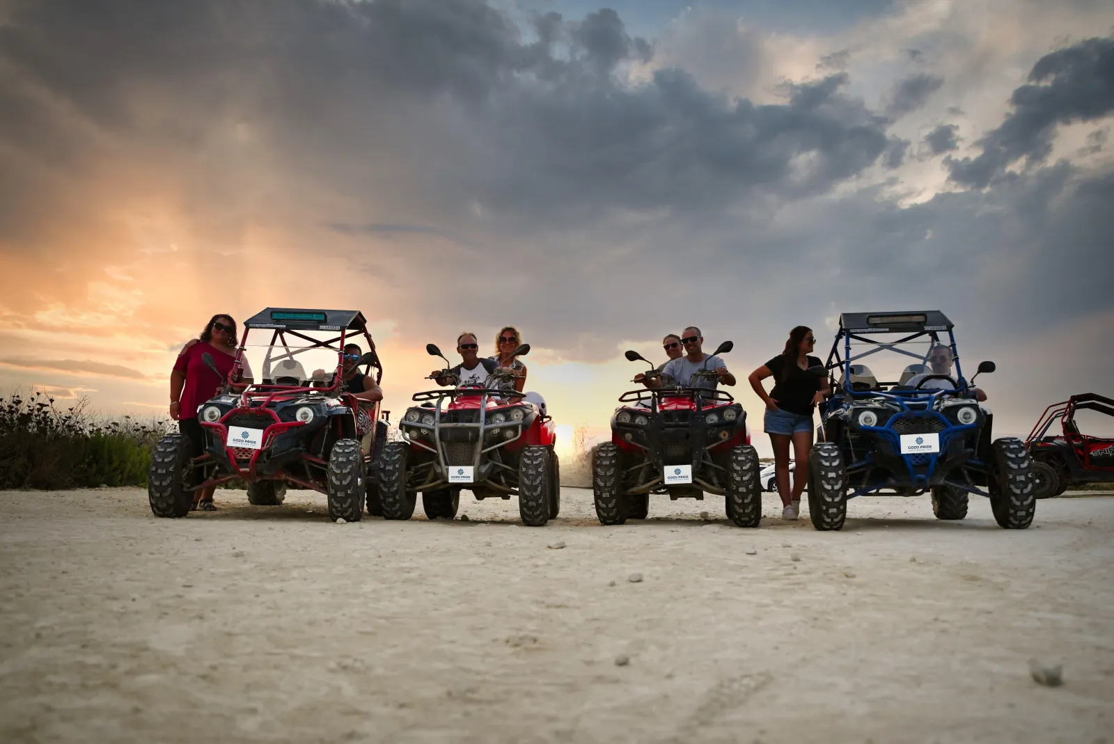 Row of quad bikes and buggies parked at sunset on a Gozo tour stop
