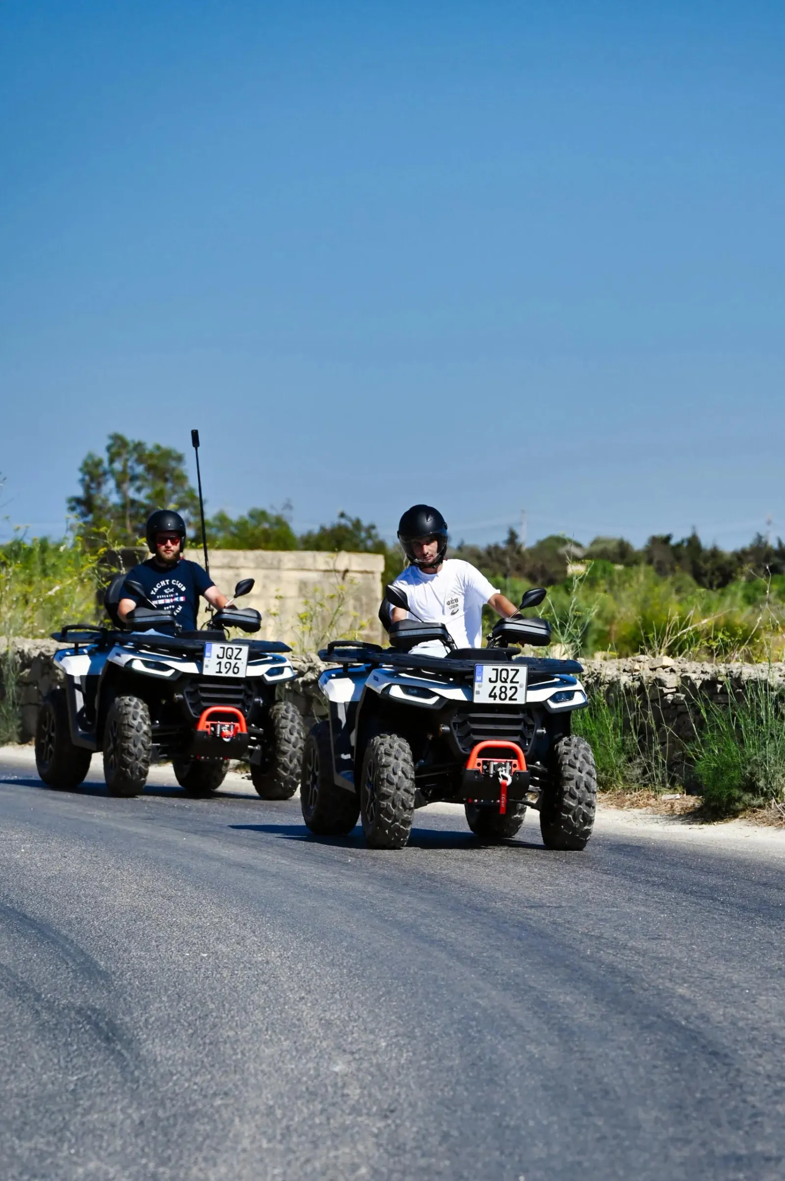 Two riders sharing a double-rider quad bike on a Gozo road