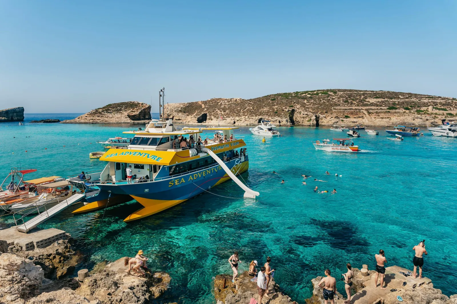 Sightseeing catamaran moored in the turquoise water of the Blue Lagoon at Comino