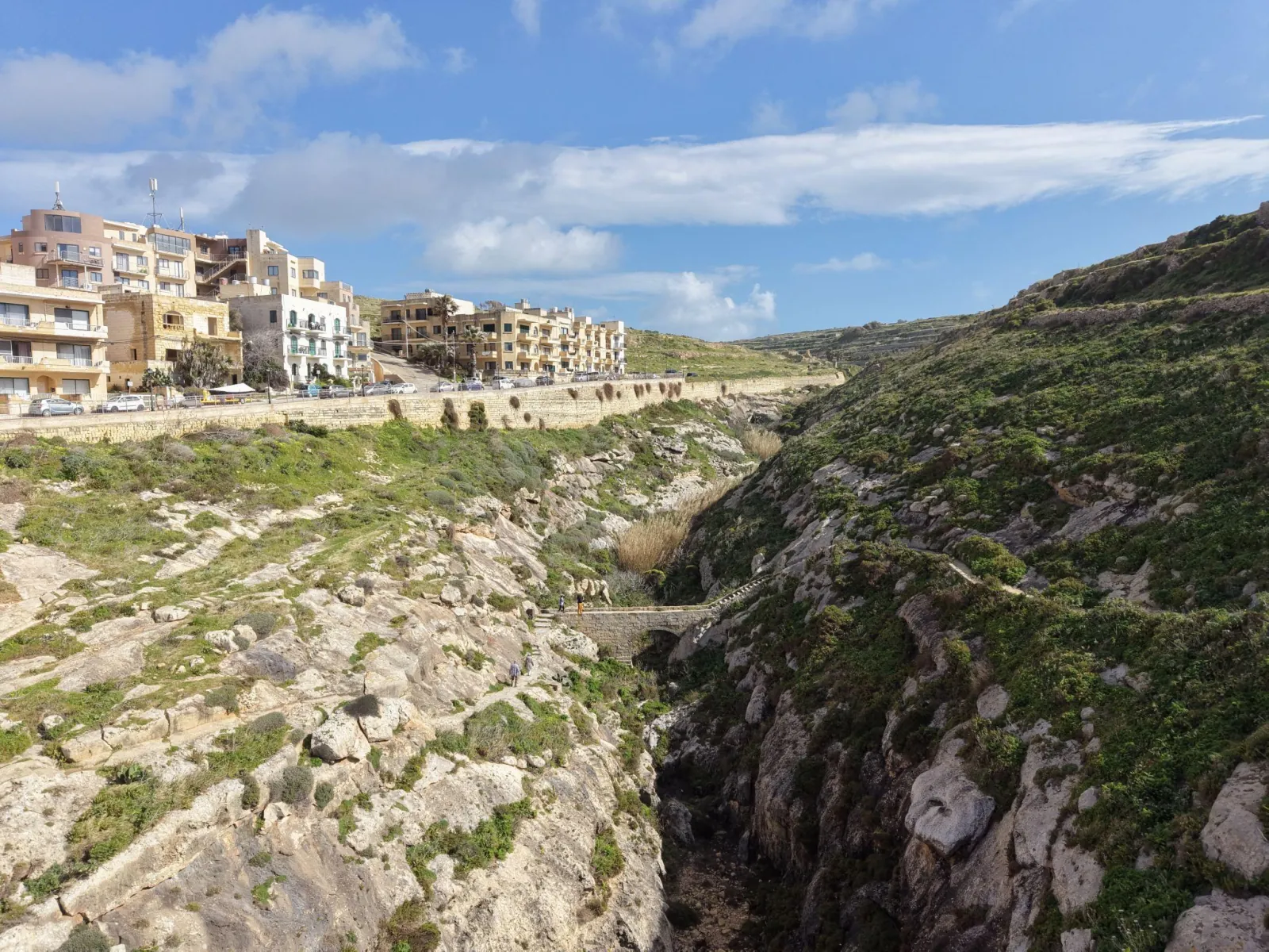Aerial view of a Gozo coastal village surrounded by terraced fields