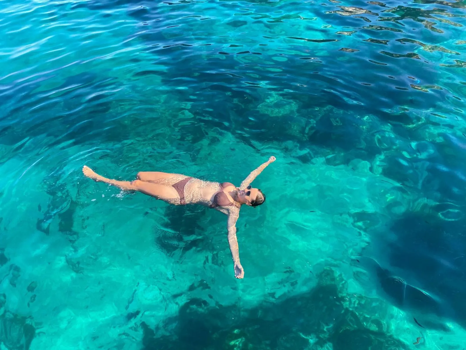 Swimmer floating in the turquoise water off Comino on a private boat charter