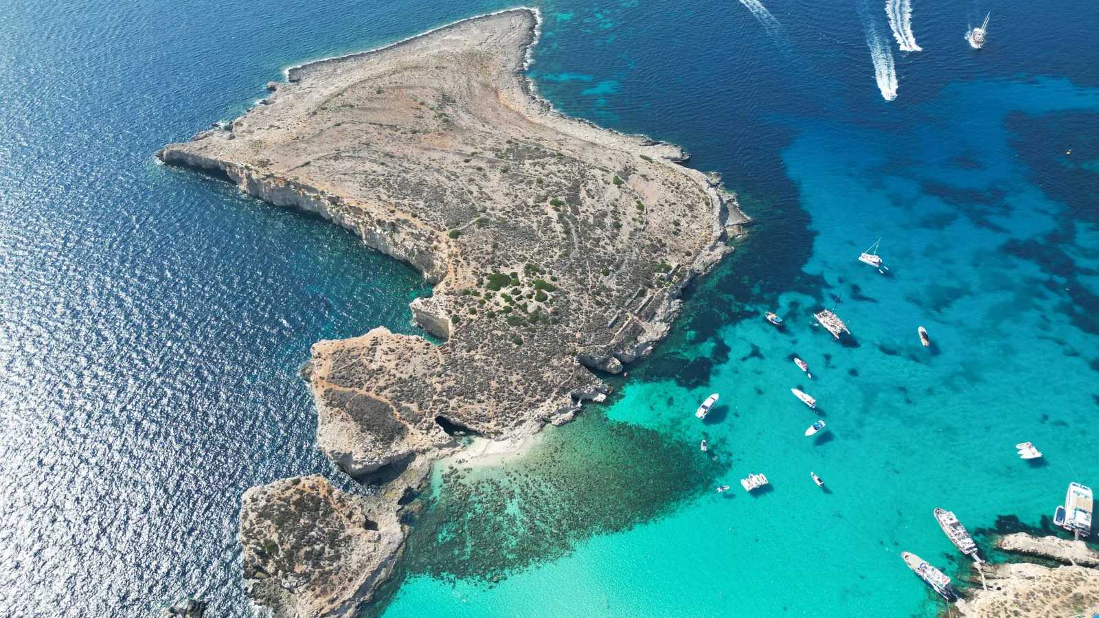 Aerial view of Cominotto island and the boats moored in the Blue Lagoon