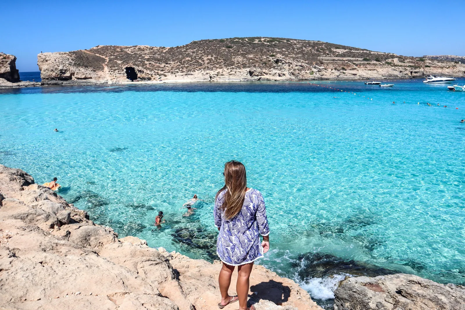Visitor wading into the shallow turquoise water at the Blue Lagoon