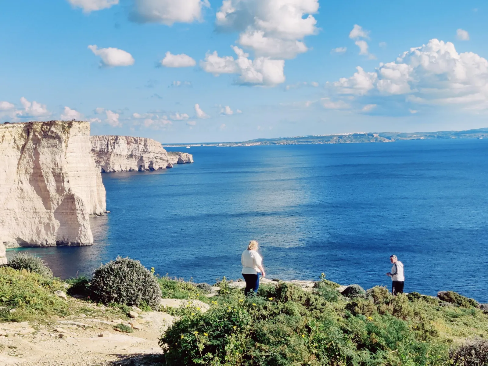Visitors on the clifftop above the sea on a private Gozo tour