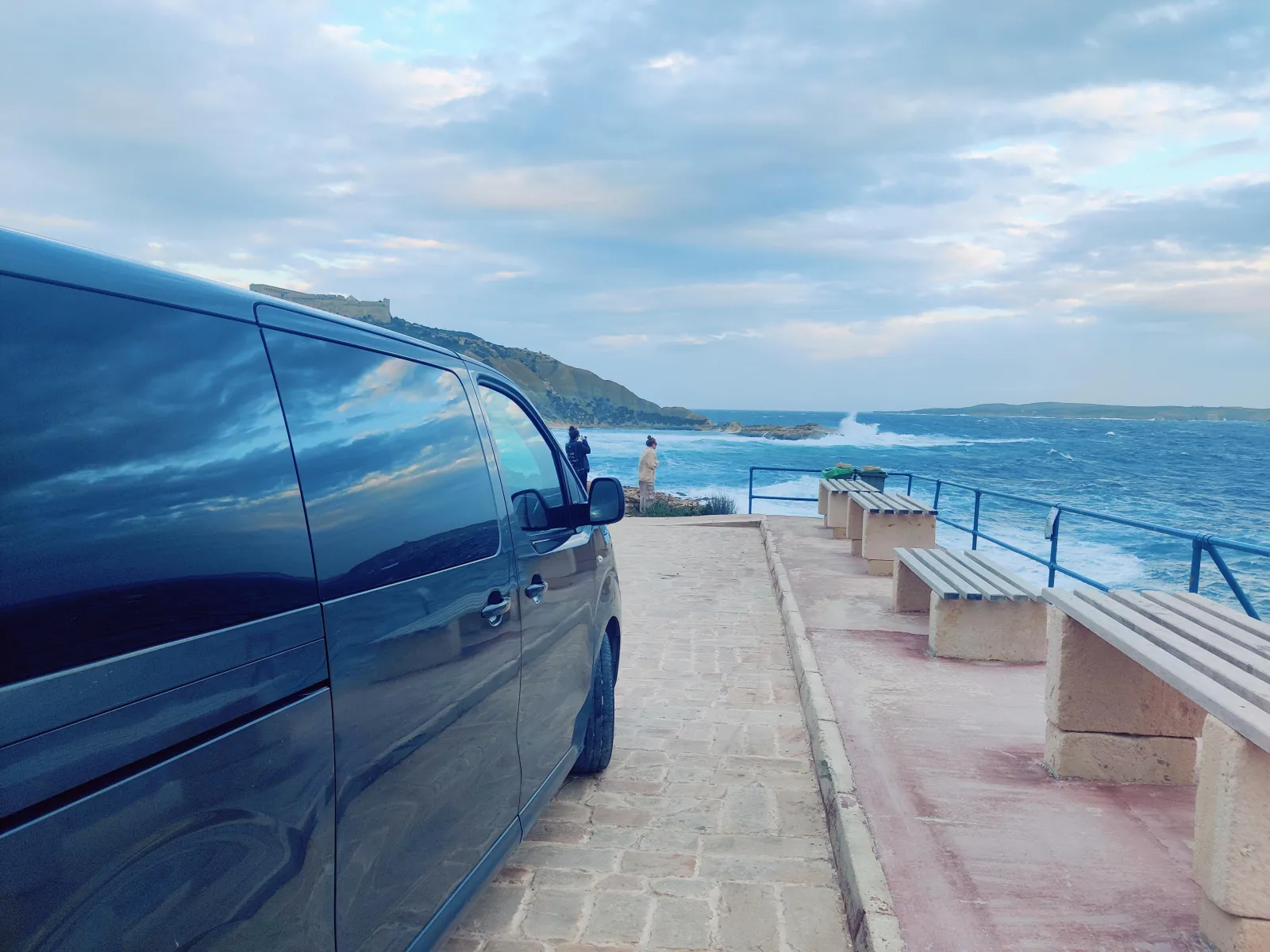 Private air-conditioned minivan parked on a Gozo seafront promenade
