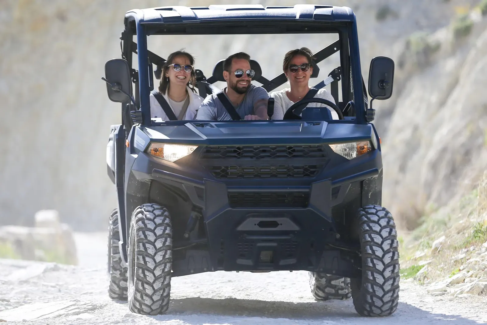 Guests riding a chauffeur-driven UTV on a Gozo dirt track